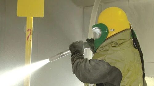 Worker in protective gear finishing a surface