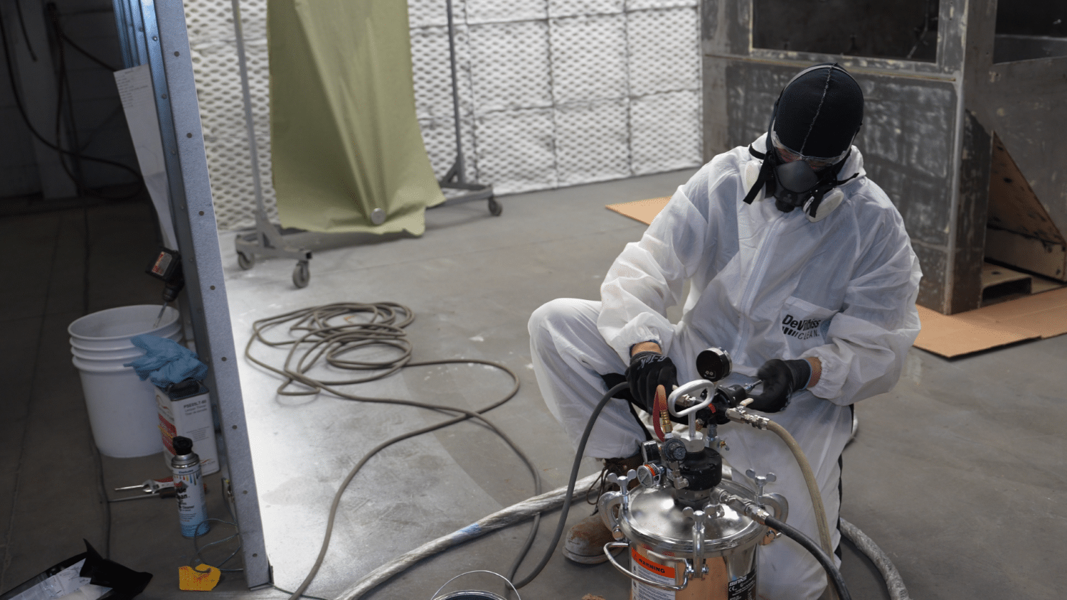 Calibrating pressure valve in paint pot specialist calibrating pressure valve in a paint pot in full ppe