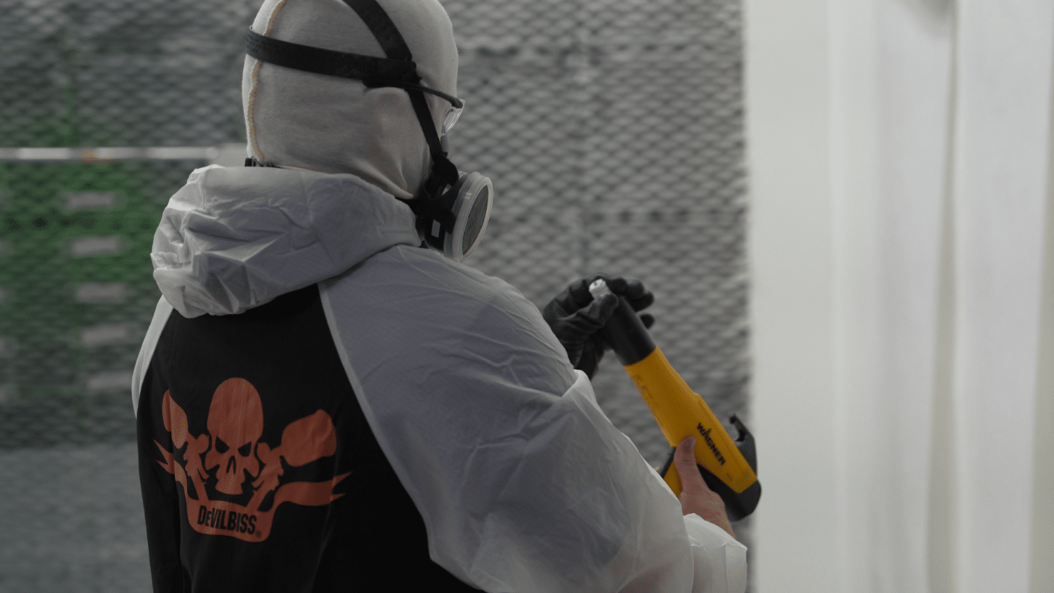 WarrantyRepairPaintandPowder A worker in devilbiss ppe looking at a wagner paint gun